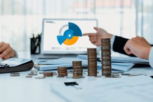 Business intelligence analyst use BI software on laptop to analyze financial data dashboard with growth stack coin symbolize business technology make investment decision in panorama. Shrewd